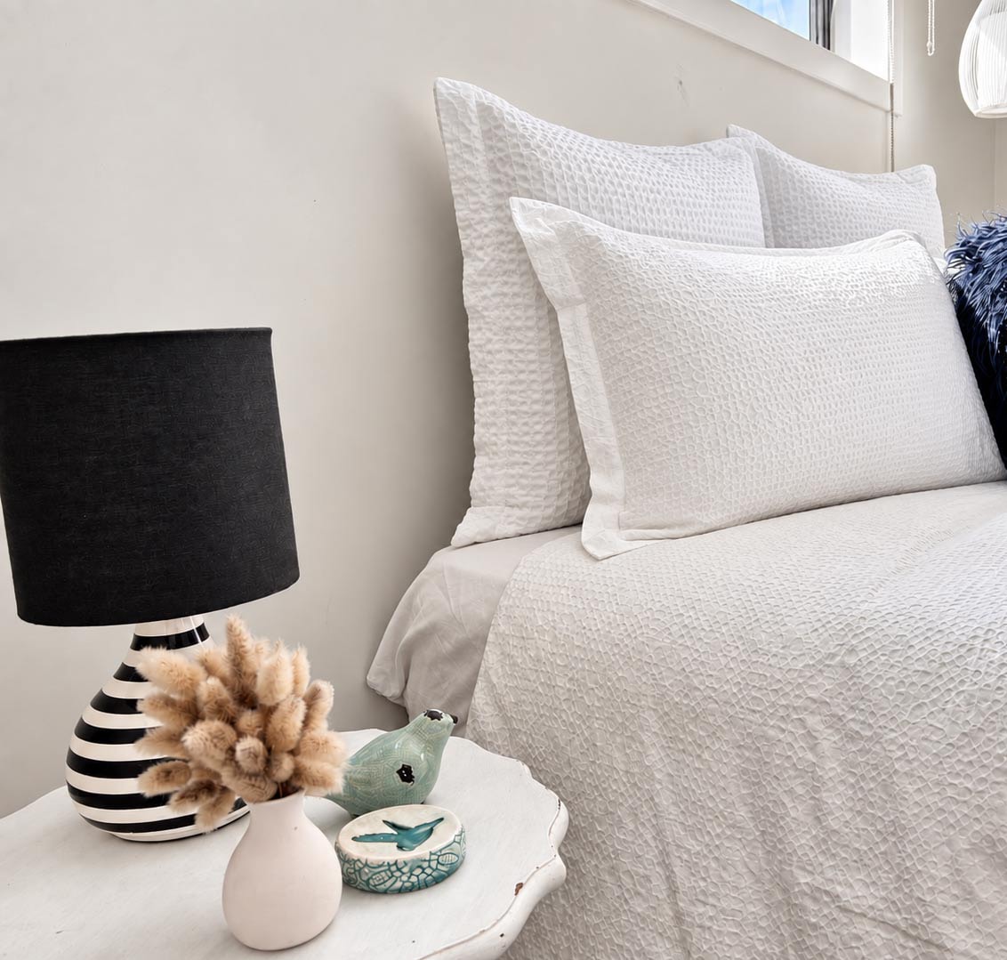 Bedroom with white textured pillows and neutral bedding
