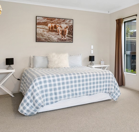 Bedroom with blue checkered bedding and neutral walls